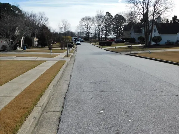 a view of swimming pool with outdoor seating and trees in the background