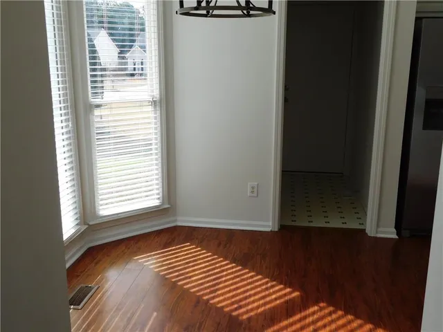 a view of a room with wooden floor and a window