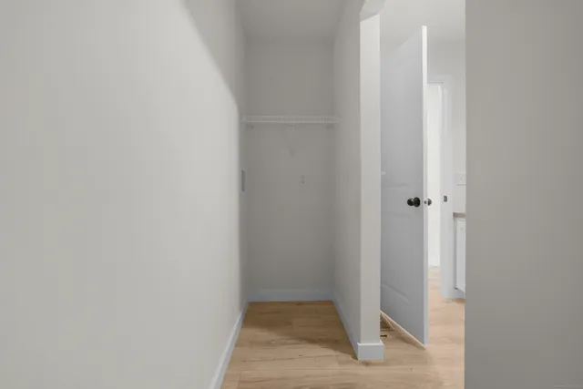 a view of a small space in front of a house with wooden fence