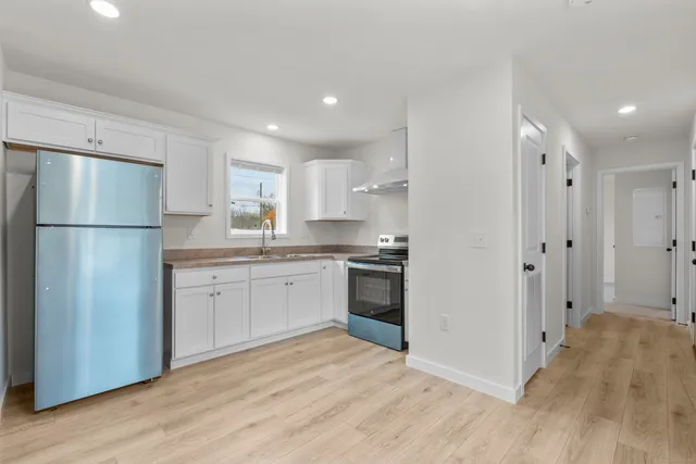 a kitchen with a refrigerator sink and cabinets