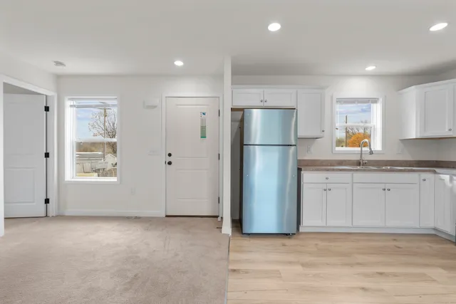 a view of kitchen with kitchen island wooden floor center island and stainless steel appliances
