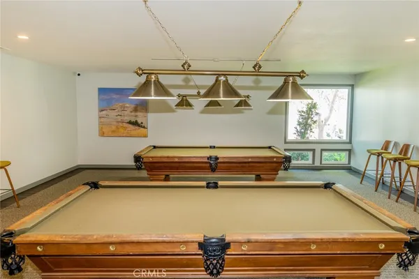 a room with pool table and windows