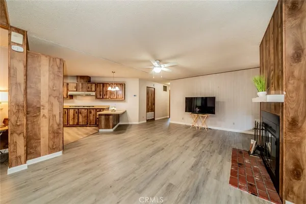 a living room with stainless steel appliances furniture a fireplace and a flat screen tv