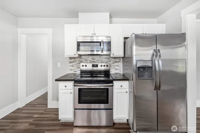 a kitchen with stainless steel appliances a stove a refrigerator and a microwave
