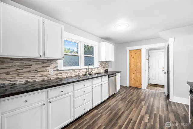 a kitchen with granite countertop white cabinets and white appliances