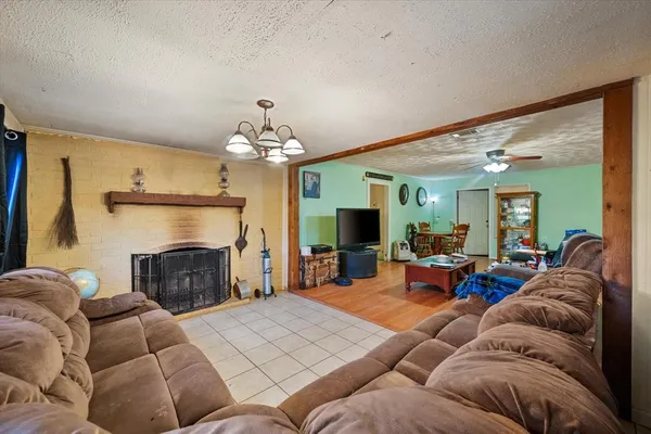 a living room with furniture a fireplace and a chandelier