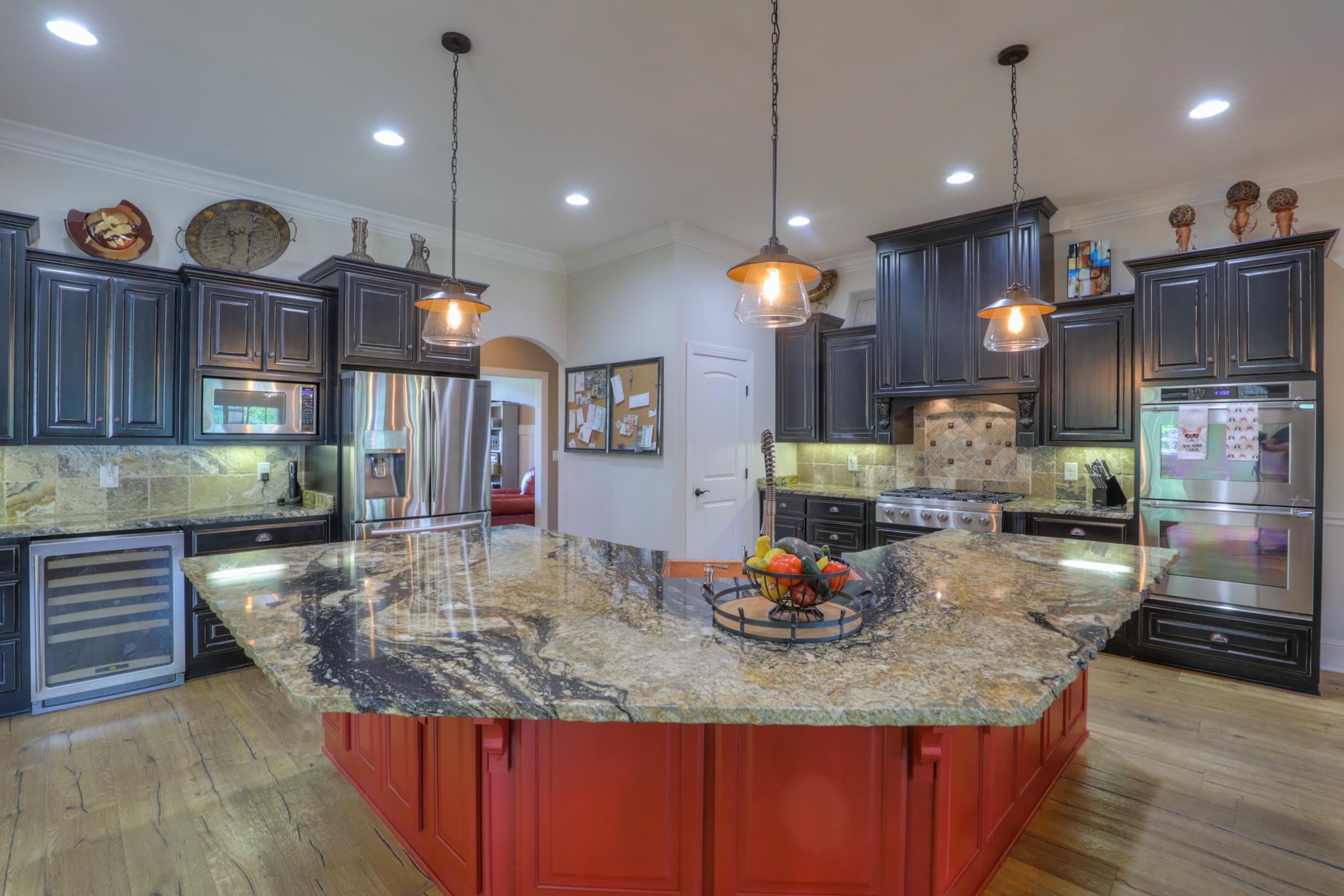 561 Cairo Bend Road Lebanon, TN 37087 - Photo 15 of 29 a kitchen with kitchen island granite countertop a stove a sink a refrigerator and chairs