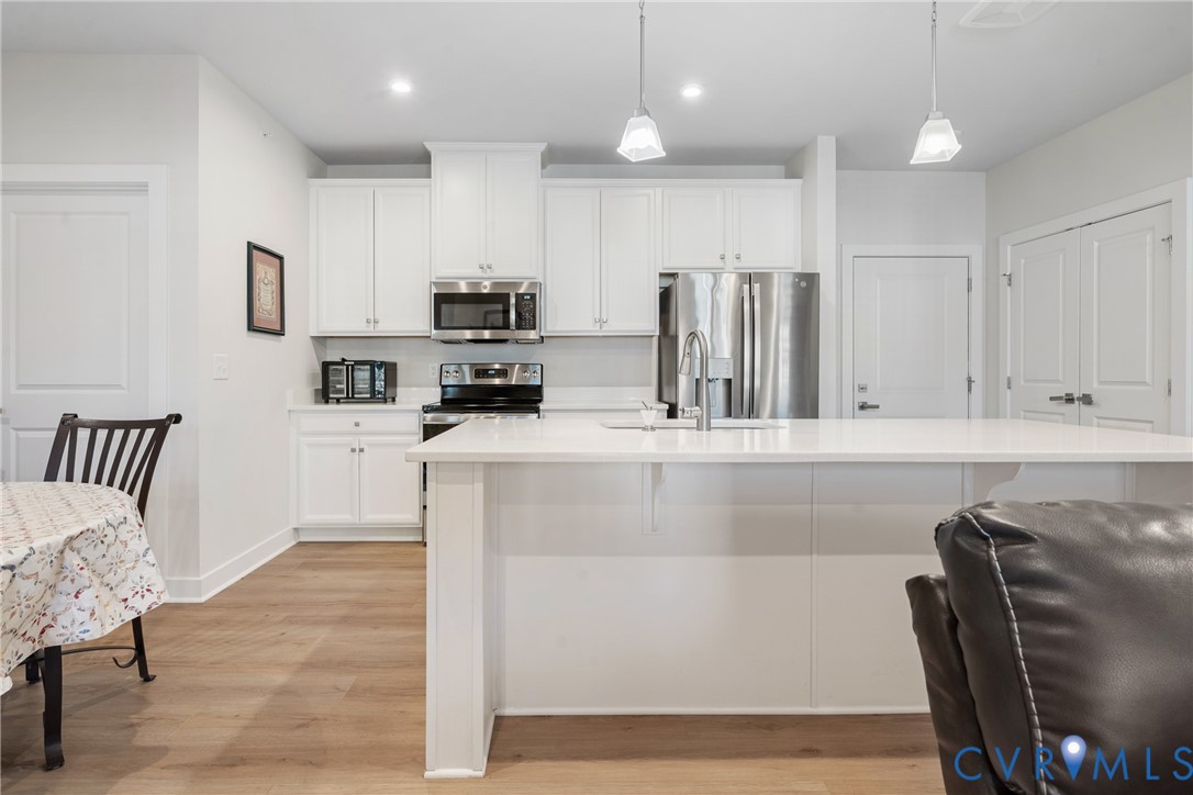 6601 Citory Way, Unit 304 Moseley, VA 23120 - Photo 5 of 33 a kitchen with stainless steel appliances granite countertop a refrigerator a stove top oven a sink with island and chairs