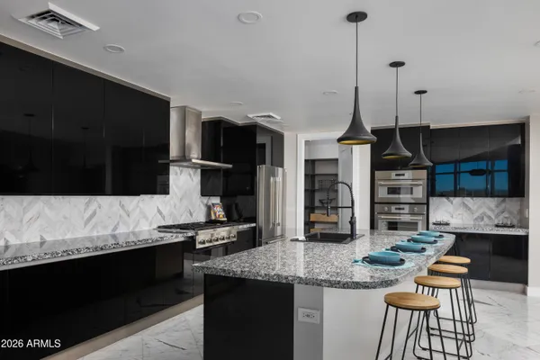 a kitchen with stainless steel appliances kitchen island granite countertop a stove a sink and a refrigerator