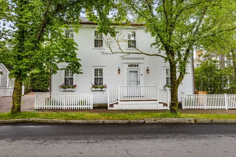 a front view of a house with a garden and plants