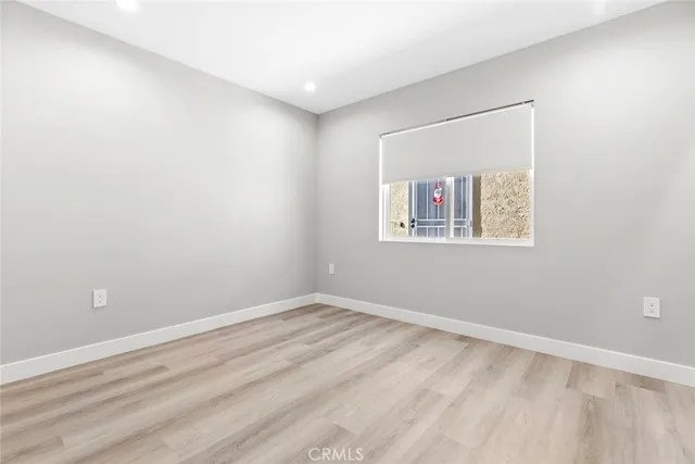 a view of an empty room with cabinet and a window