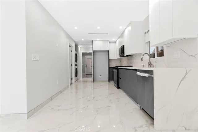 a kitchen with granite countertop a refrigerator and a sink