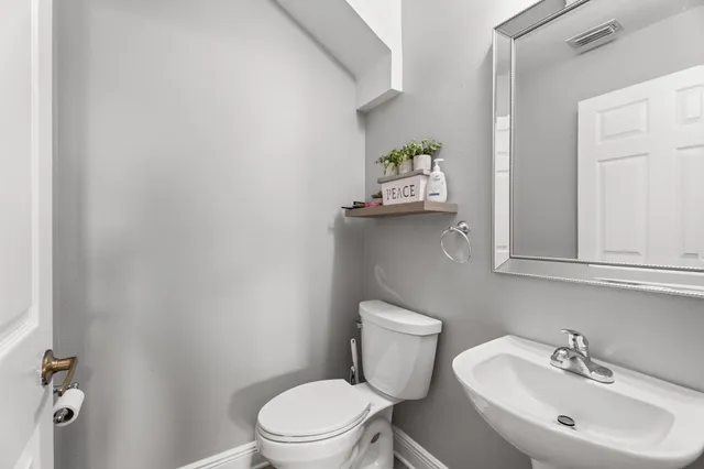 a white toilet sitting next to a bathroom sink
