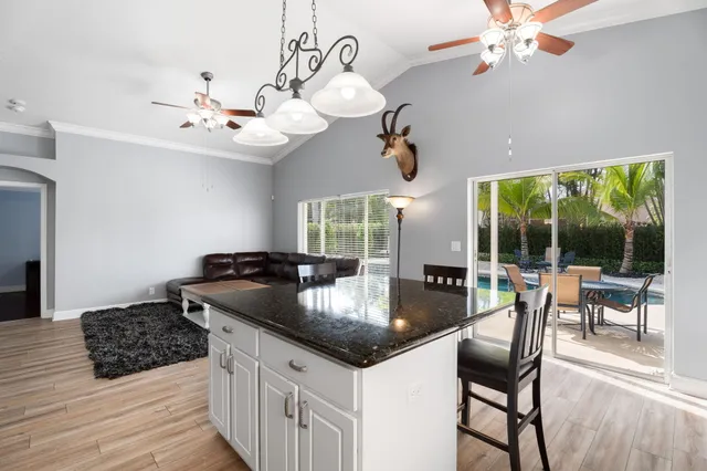 a kitchen with a counter space a sink appliances and living room view