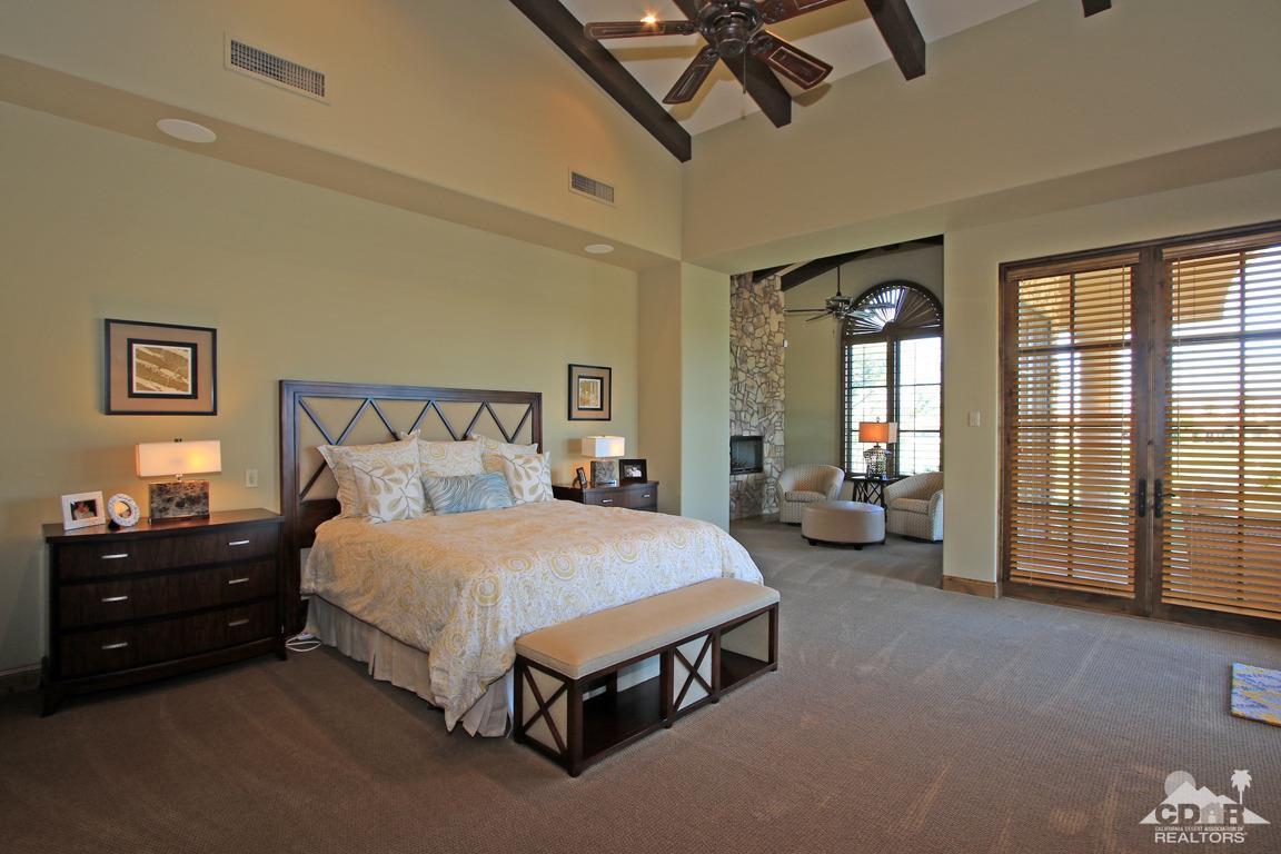 57300 Peninsula Lane La Quinta, CA 92253 - Photo 36 of 97 a spacious bedroom with a bed and a chandelier