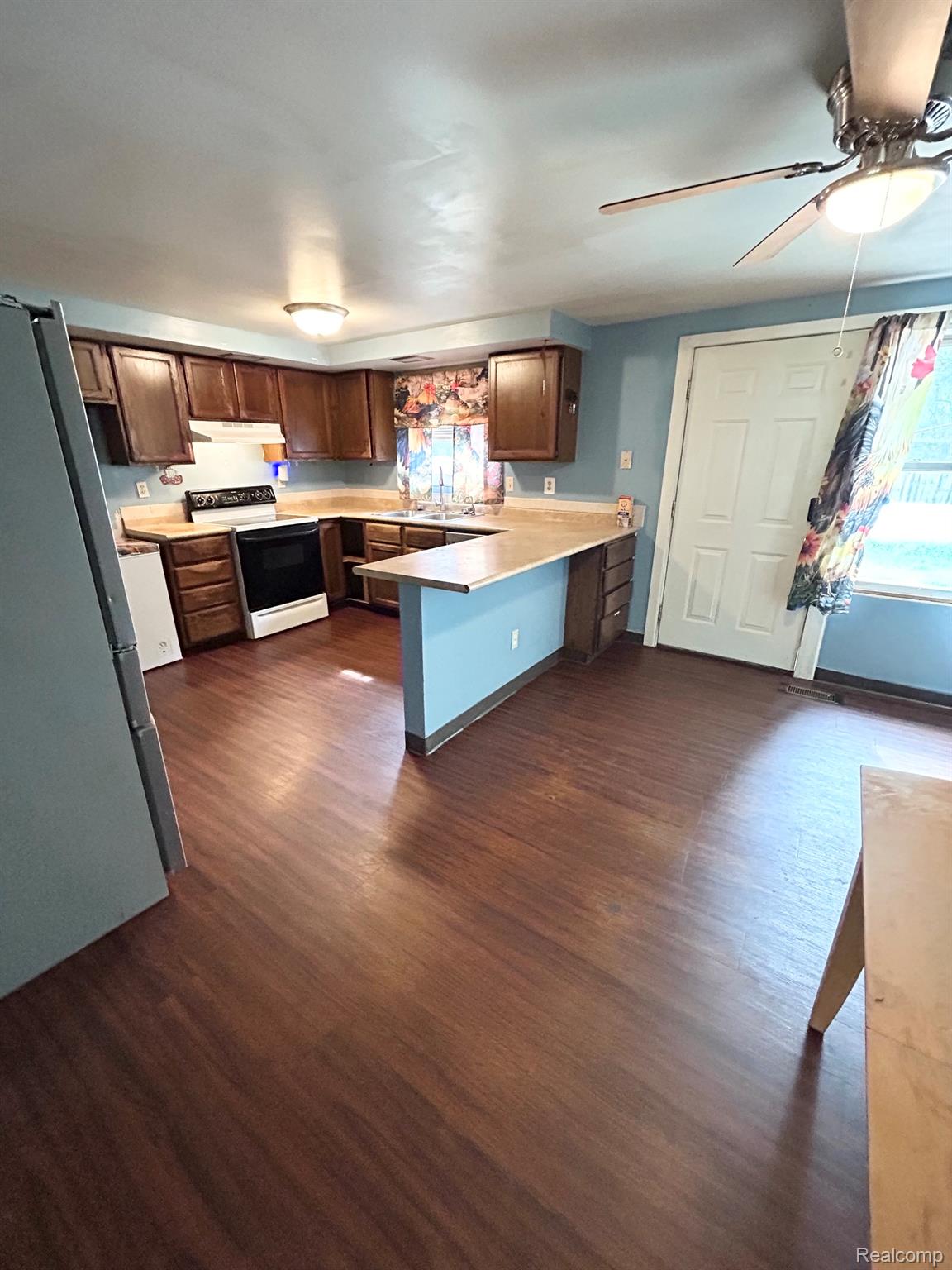 140 Larson Road Attica, MI 48412 - Photo 17 of 41 Kitchen featuring wood-finish flooring, wood cabinetry, light countertops, and a ceiling fan with integrated lighting
