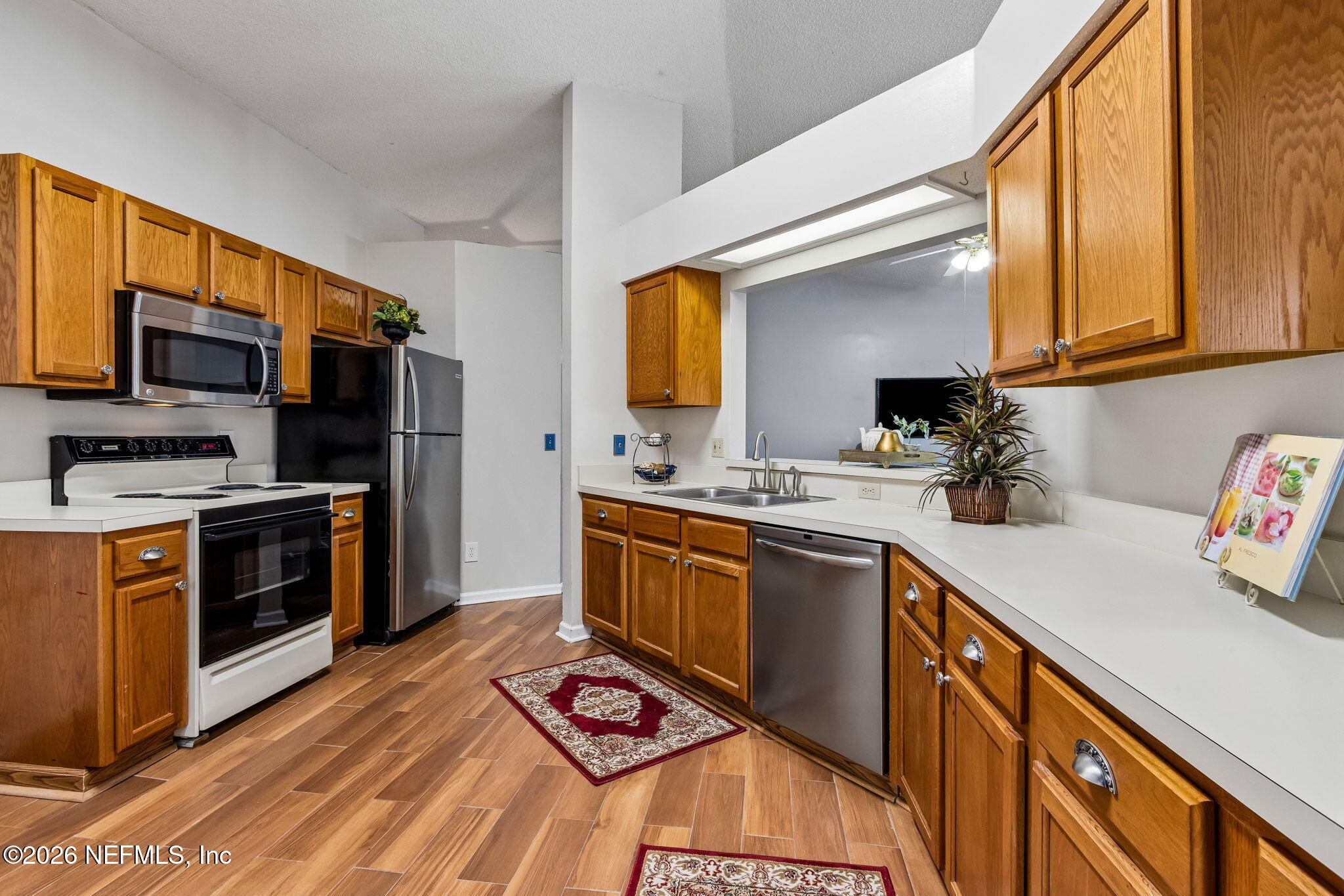 12648 Moose Road Jacksonville, FL 32226 - Photo 12 of 38 a kitchen with stainless steel appliances a stove sink microwave and cabinets