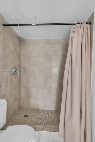 a bathroom with a shower toilet and sink