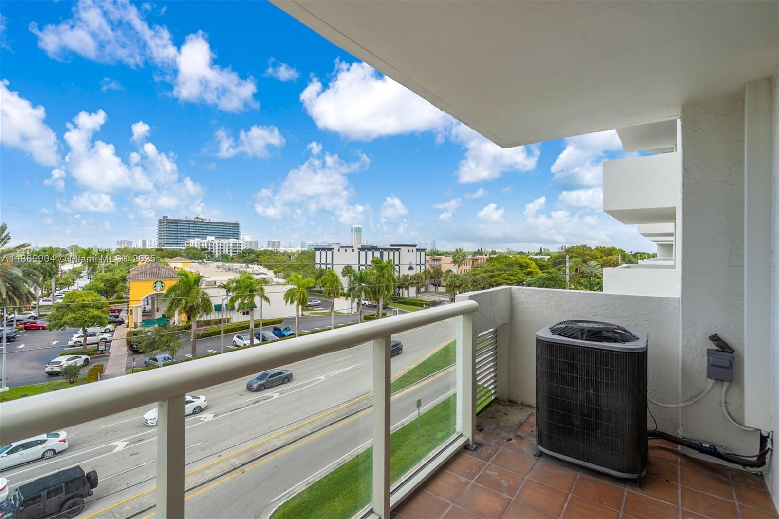 13499 Biscayne Boulevard, Unit 403 North Miami, FL 33181 - Photo 20 of 31 a view of a balcony with wooden floor and a potted plant