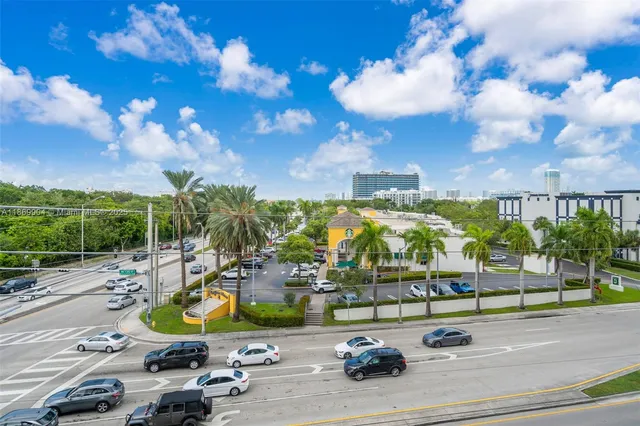 a view of a tennis ground with large trees