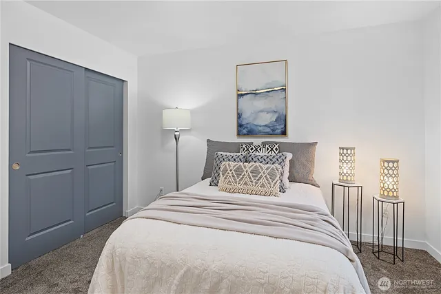 a bedroom with a bed and a painting on the wall