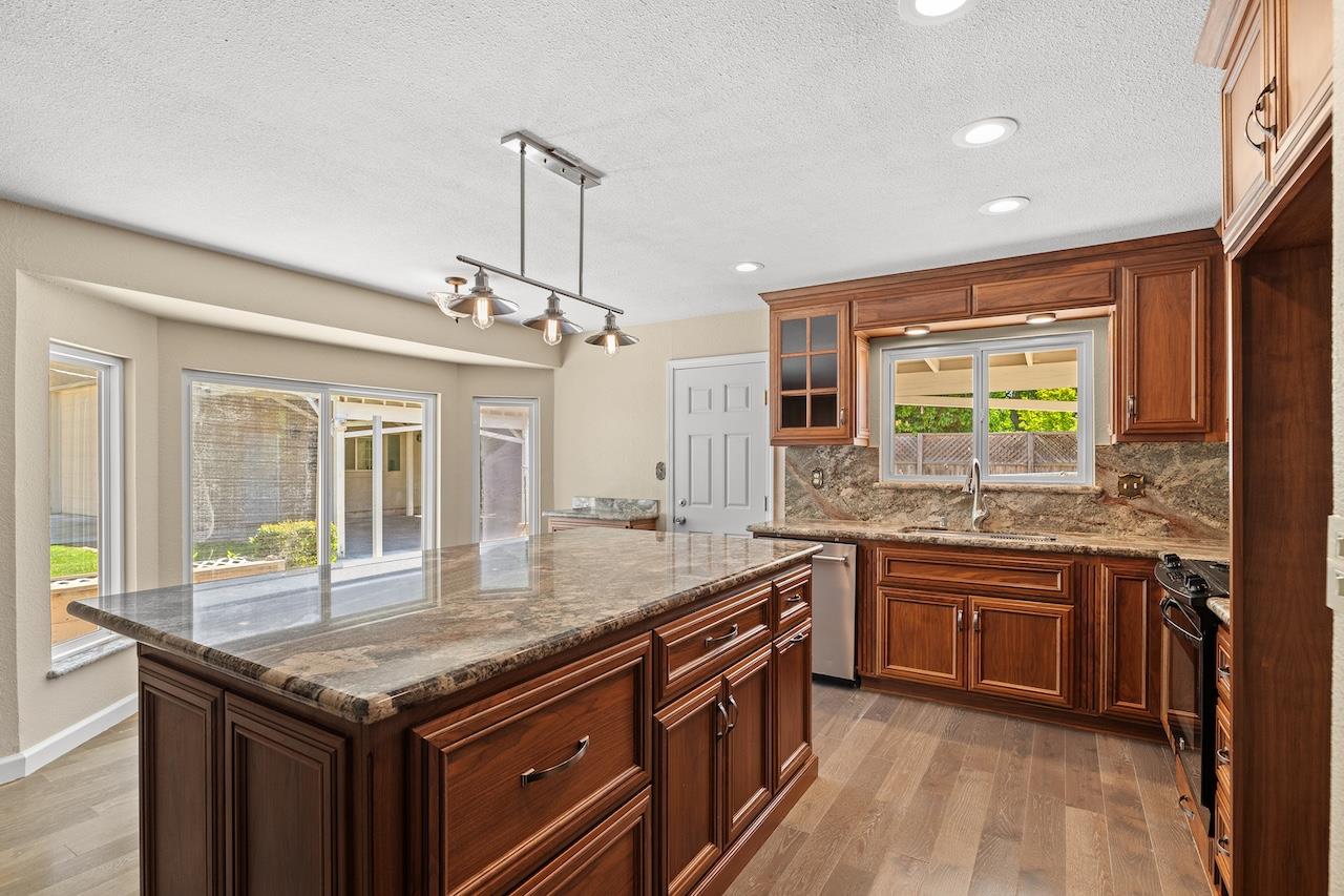 940 Constitution Way Tracy, CA 95376 - Photo 18 of 63 a kitchen with granite countertop cabinets a sink dishwasher and wooden floor