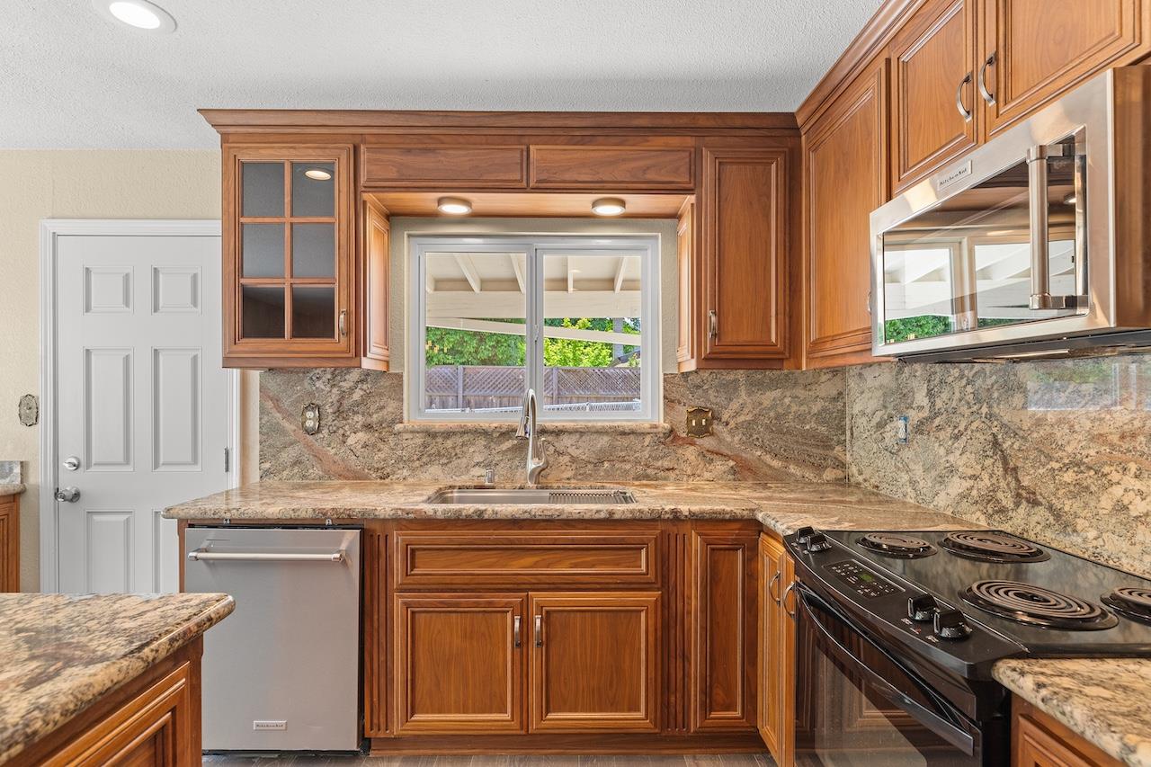 940 Constitution Way Tracy, CA 95376 - Photo 21 of 63 a kitchen with granite countertop a sink stove and cabinets