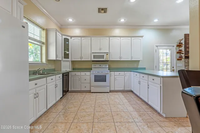 a large kitchen with granite countertop a large counter top space a sink stainless steel appliances and cabinets