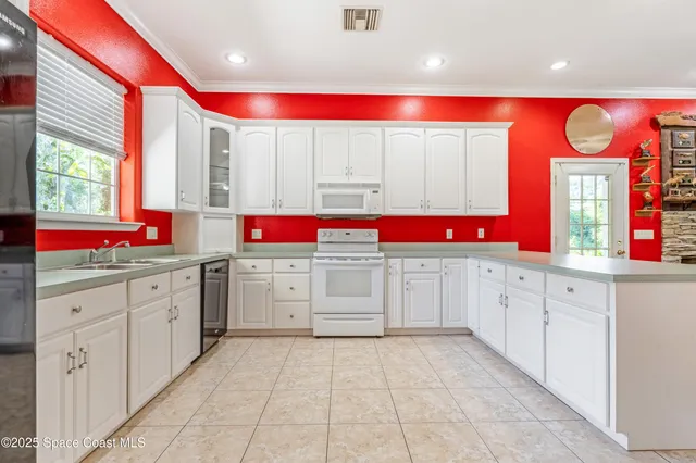 a kitchen with granite countertop a sink and white cabinets