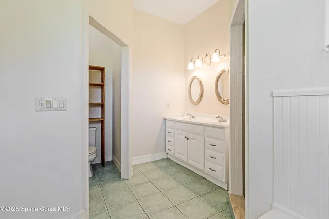 a spacious bathroom with a double vanity sink and a mirror