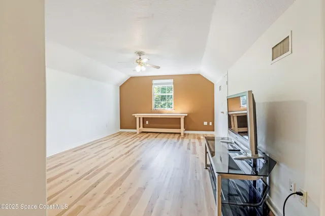 a view of a livingroom with wooden floor and furniture