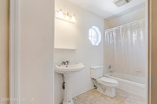 a white toilet sitting next to a bathroom sink