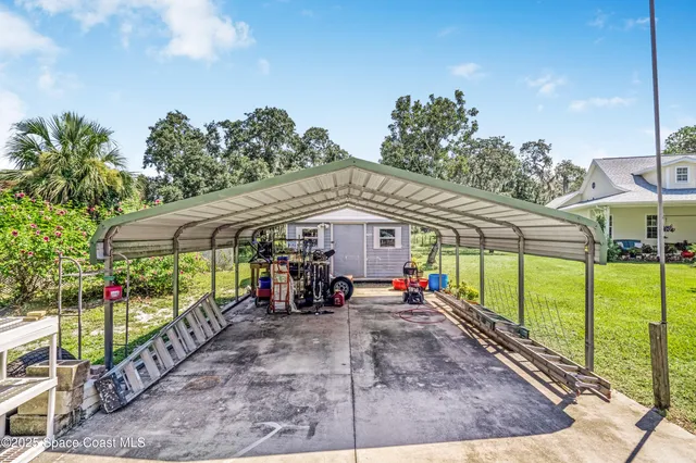 a view of a patio with table and chairs under an umbrella