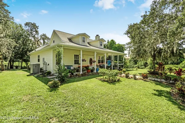 a view of a house with backyard garden and sitting area