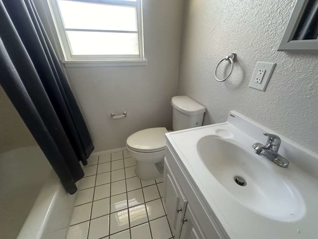 2424 East 28th Street Lubbock, TX 79404 - Photo 10 of 14 a bathroom with a sink and a toilet