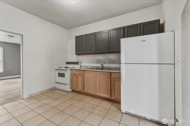 a kitchen with a refrigerator sink and cabinets