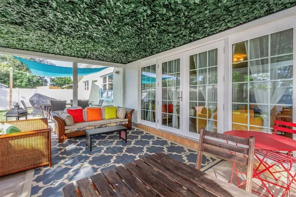 a outdoor living room with furniture and a floor to ceiling window