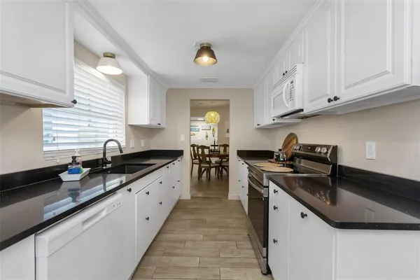 a kitchen with stainless steel appliances granite countertop a refrigerator and a sink