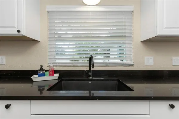 a bedroom with a bed and a flat tv screen on dresser