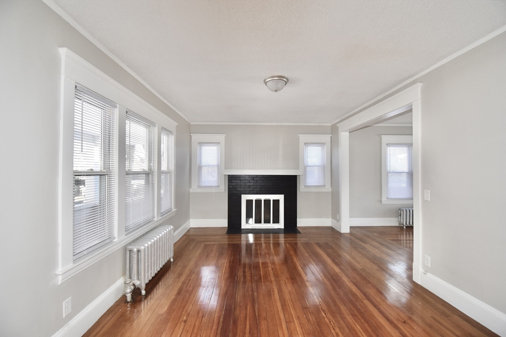 34 Castle Street Springfield, MA 01118 - Photo 11 of 29 a view of empty room with wooden floor and fireplace