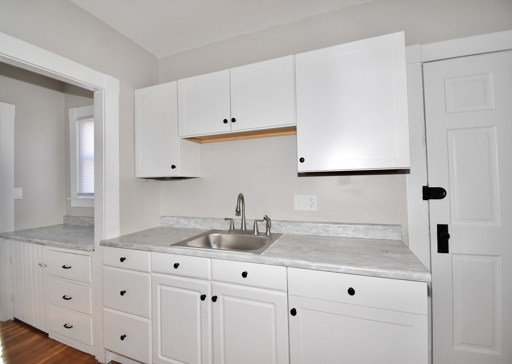 34 Castle Street Springfield, MA 01118 - Photo 12 of 29 a kitchen with granite countertop white cabinets and white appliances