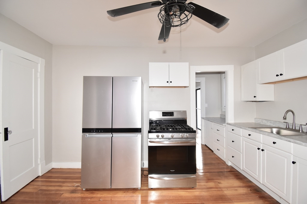 34 Castle Street Springfield, MA 01118 - Photo 14 of 29 a kitchen with stainless steel appliances a refrigerator a stove and white cabinets