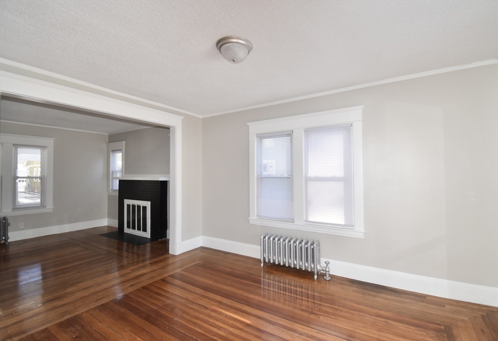 34 Castle Street Springfield, MA 01118 - Photo 6 of 29 an empty room with wooden floor and a window