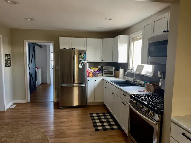 a kitchen with a stove a refrigerator and a stove top oven