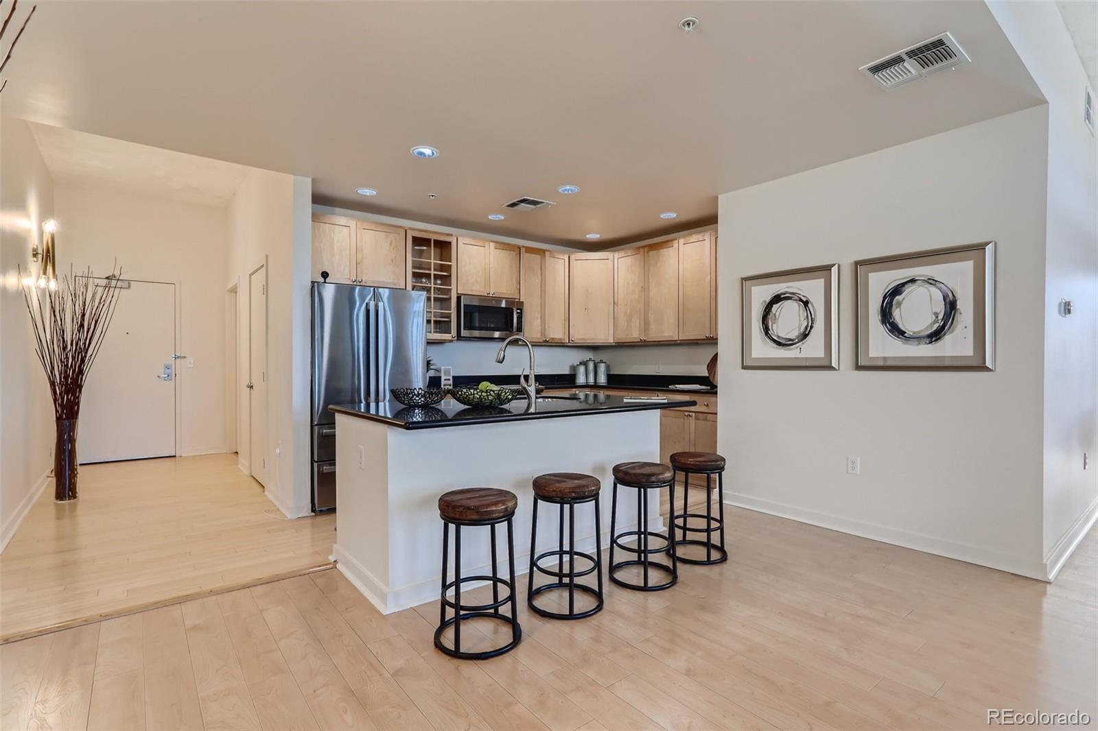 275 South Harrison Street, Unit 602 Denver, CO 80209 - Photo 12 of 33 a kitchen with stainless steel appliances a refrigerator and a stove top oven