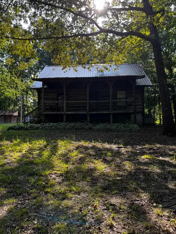a view of a house with a large tree and a yard
