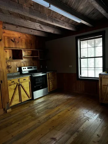 a kitchen with stainless steel appliances wooden cabinets and a wooden floor