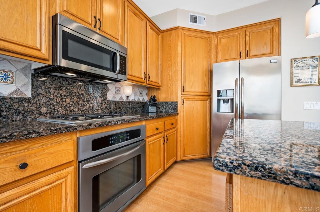 533 Anchorage Avenue Carlsbad, CA 92011 - Photo 10 of 58 a kitchen with stainless steel appliances granite countertop a stove microwave and refrigerator