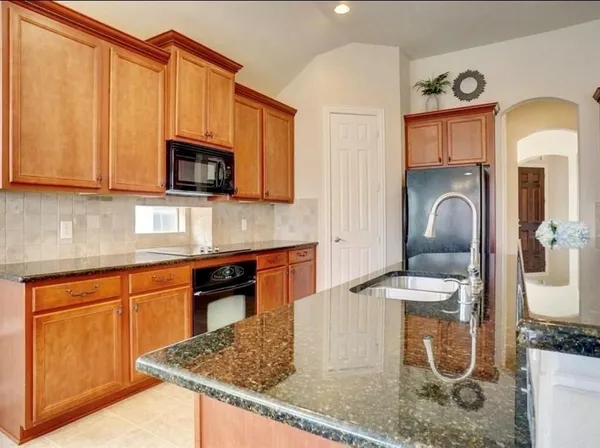 a kitchen with stainless steel appliances granite countertop a sink a microwave cabinets and a stove
