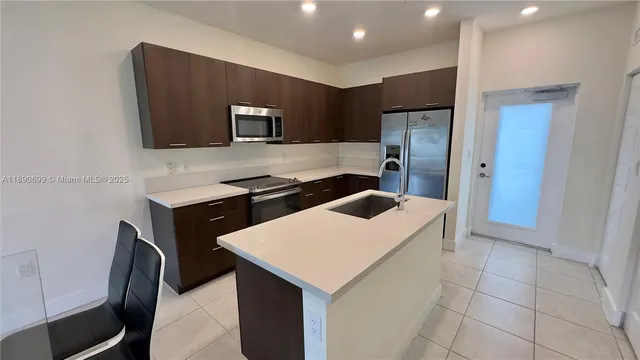 a kitchen with stainless steel appliances a microwave a sink and a refrigerator